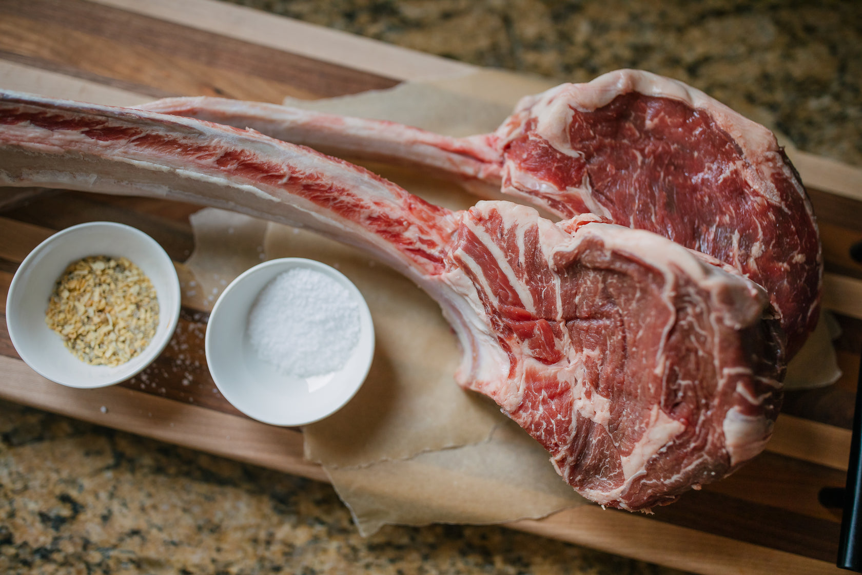 tomahawk steak with seasoning in dishes
